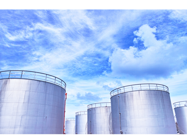 Large storage tanks arranged in lines with sky in background