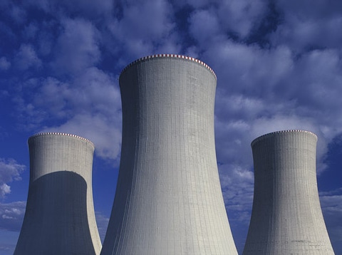 View of three tall cylindrical nuclear tanks with sky in background