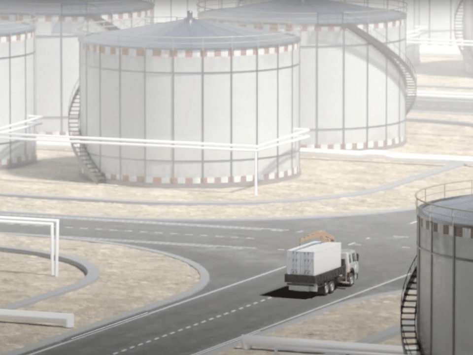 truck driving by multiple storage tanks